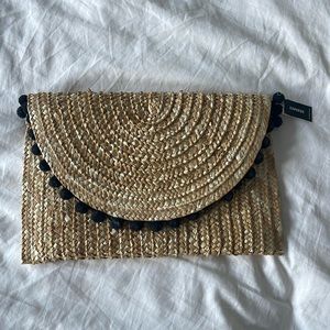 Boho straw clutch with black pom decor